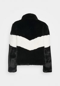 Zwart-witte nepbontjas met een chevronpatroon. Het ontwerp heeft een hoge kraag en een zachte textuur, geschikt voor casual wear.