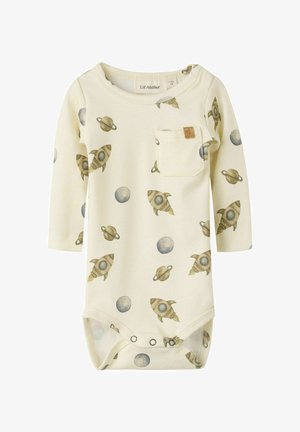Body para bebé de color crema con mangas largas que presenta estampados de cohetes y planetas, detalle de bolsillo y cierres a presión en la parte inferior. Textura de tela suave.