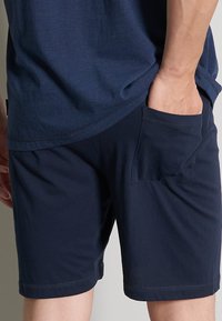 Dunkelblaue Shorts aus weichem Stoff, mit einer Gesäßtasche und genähtem Saum. Das Design ist schlicht mit einer lockeren Passform.