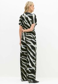 Mono de estampado en blanco y negro con mangas cortas, un corte relajado y piernas anchas, fabricado en un tejido suave y ligero.