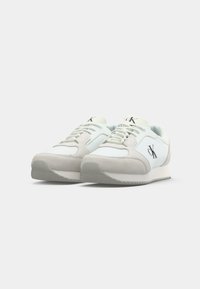 Witte sneakers met lichtgrijze suede accenten, met een klassiek ontwerp, een gestructureerde rubberen zool en logodetail aan de zijkant.