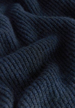 Marinblått stickat tyg med tjock ribbad struktur, mjukt utseende och lätt fuzzighet, vilket skapar en varm, texturerad yta.