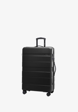 Maleta rígida negra con surcos horizontales, un mango retráctil y cuatro ruedas para movilidad. Incluye un mango lateral y cierre de cremallera.