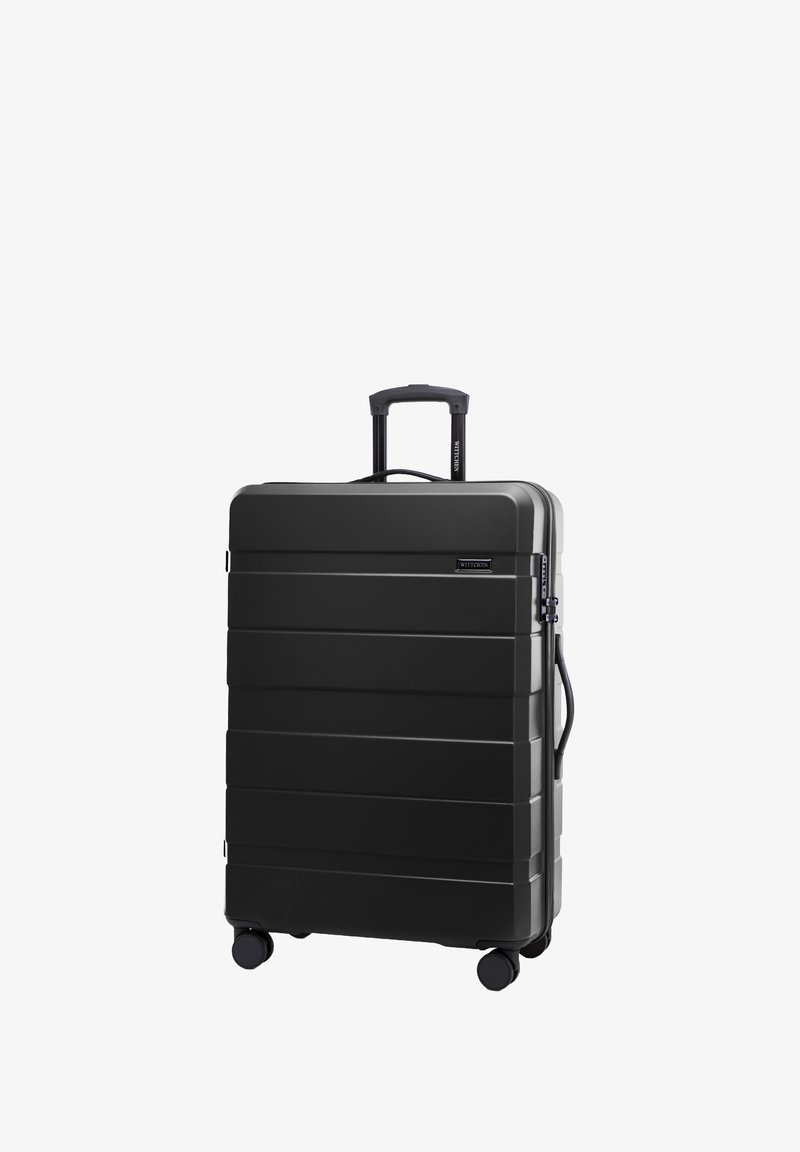 Černý pevný kufr s vodorovnými rýhami, vysouvatelnou rukojetí a čtyřmi kolečky pro snadnou manipulaci. Má boční rukojeť a zipové zavírání.