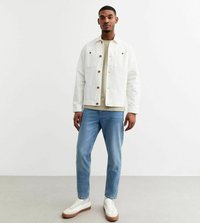 Witte denimjasje met bruine knopen, beige t-shirt, lichtblauwe jeans en witte sneakers met bruine zolen. Eenvoudige, casual kledingoutfit.