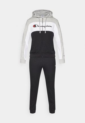 Černý a šedý sportovní komplet s mikinou na zip a úzkými kalhotami. Obsahuje bílý středový panel a červené logo "Champion" na hrudi.