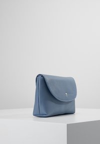 Borsa in pelle blu con finitura testurizzata, dotata di chiusura a patta e piccolo dettaglio con bottone argento. Forma rettangolare dal design minimalista.