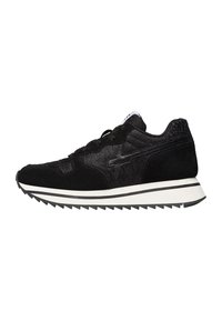 Sneaker atletico nero con tomaia testurizzata, suola bianca con strisce nere e motivo a zigzag sulla suola, su sfondo bianco.