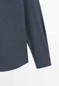 Mouw en zijnaden van een donkergrijze longsleeve met een rechte manchet en licht gebogen zoom op een witte achtergrond.