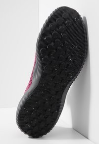 Semelle extérieure noire avec adhérence texturée et motifs circulaires ; tige rose en matériau respirant ; design élégant avec bords arrondis.