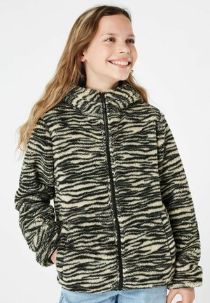 Veste en polaire zébrée noire et crème avec un col haut, fermeture éclair sur le devant et poches latérales. Texture douce et design ample.