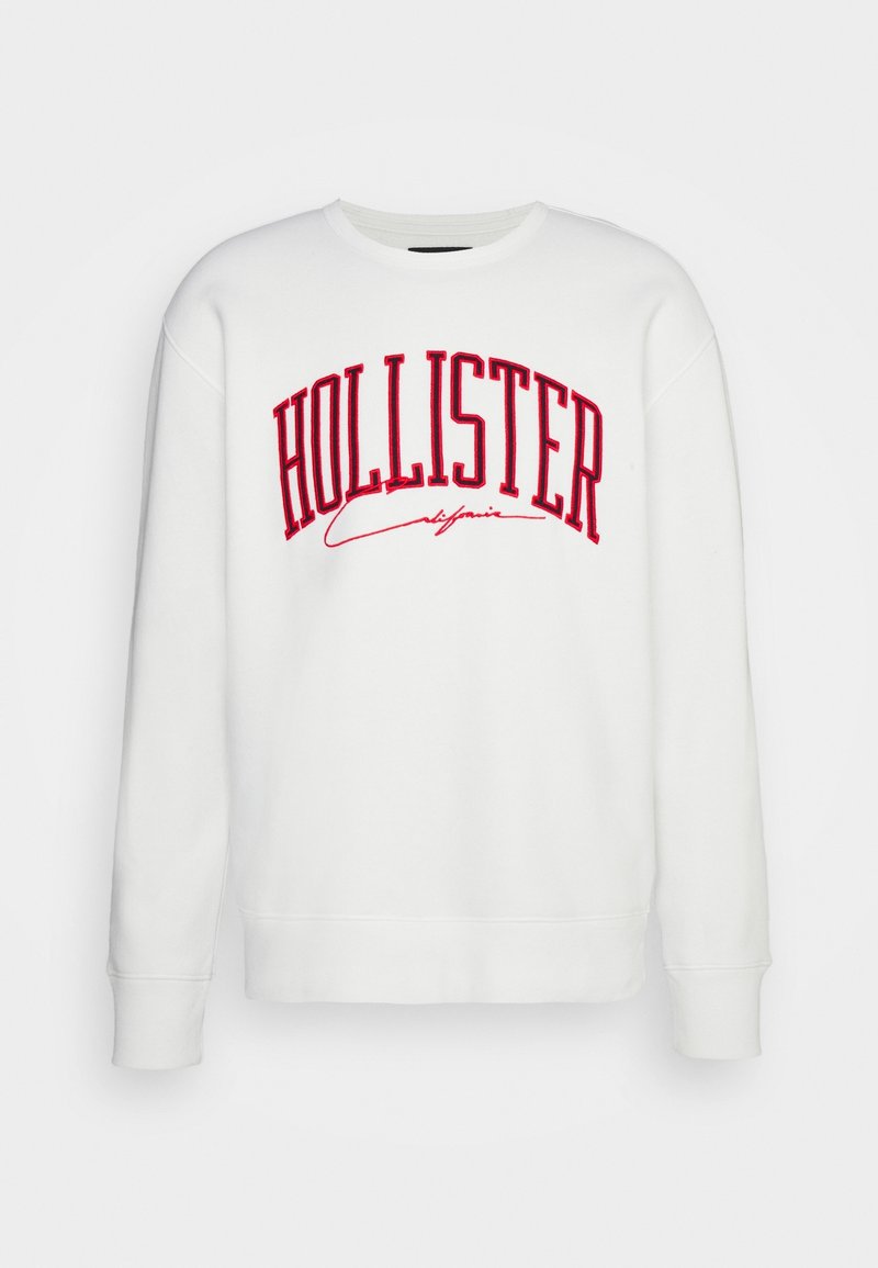 Witte sweatshirt met rood "HOLLISTER California" logo. Heeft een ronde hals, lange mouwen en geribbelde boorden. Zachte textuur.