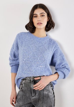 Maglione lavorato a maglia di colore azzurro chiaro con un motivo a rombi e paillettes sottili, dotato di maniche oversize e scollo rotondo a costine.