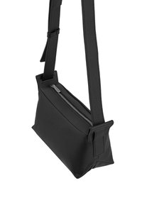 Sort læder crossbody taske med rektangulær facon, struktureret overflade, justerbar rem og sølvfarvet lynlås. 