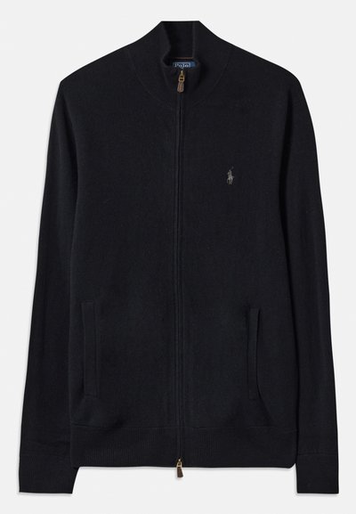 Μαύρο ζιβάγκο φούτερ με φερμουάρ, κατασκευασμένο από πλεκτό ύφασμα, που διαθέτει ψηλό γιακά, δύο μπροστινές τσέπες και ένα μικρό κεντημένο λογότυπο στο στήθος.