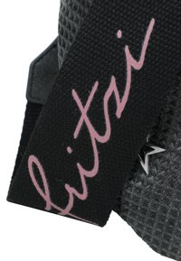 Black textile strap with pink cursive text. The background features a textured surface with geometric patterns and silver detailing.
