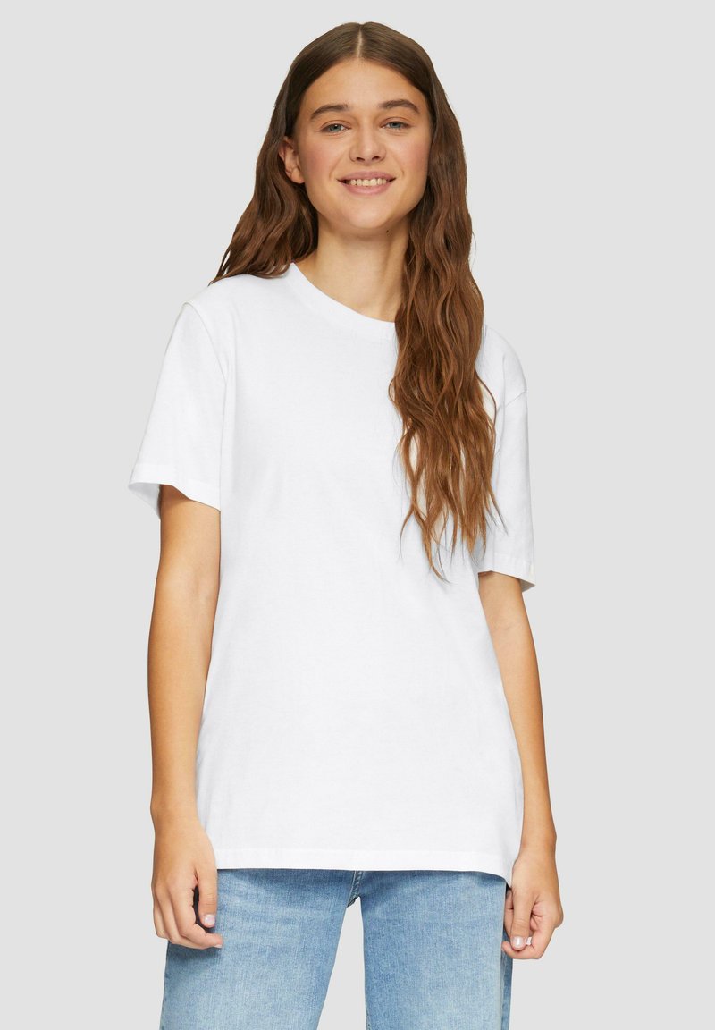 Witte katoenen t-shirt met een klassieke ronde hals, korte mouwen en een relaxte pasvorm. Glad textuur en eenvoudig ontwerp, gecombineerd met lichte denim.