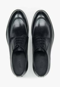 Czarne sk�órzane buty o polerowanym wykończeniu, zaokrąglonym nosku i dekoracyjnym przeszyciu. Posiadają sznurowaną konstrukcję i wyściełaną wkładkę.