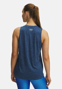 Blauer Sport-Top aus strukturiertem Material, mit Rundhalsausschnitt und Racerback-Design. Logo auf dem oberen Rücken angebracht.