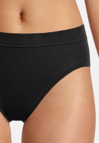Schwarze Baumwollslips mit glatter Textur, elastischem Bund und klassischem Slip-Design, das einen tiefen Schnitt und minimale Nähdetails zeigt.