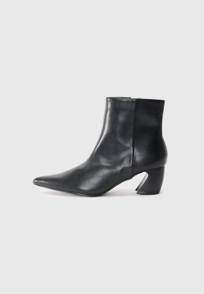 Stivaletto in pelle nera con punta appuntita, silhouette slim e un distintivo tacco a blocco geometrico. Texture liscia con zip laterale.