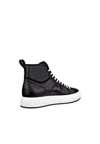 Korkeat mustat nahkasisäkengät, joissa on teksturoitu pinta, valkoiset nauhat ja paksu valkoinen pohja. Sisältää hienovaraisia ilmanvaihtoaukkoja ja vetoketjun.