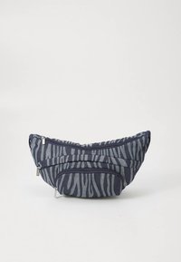 Marineblauwe stoffen tas met een zebraprint, voorzien van twee compartimenten met rits en een unieke gebogen vorm.