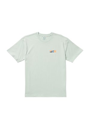 Mintinvihreä puuvillati-shirt, jossa on lyhyet hihat. Vasemmassa rintataskussa on pieni graafinen kuvio oranssina ja sinisenä.