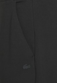 Zwarte sweatpants van een katoenmix met een slim fit, zijzakken en een geborduurd logo aan de zijkant voor subtiele branding.