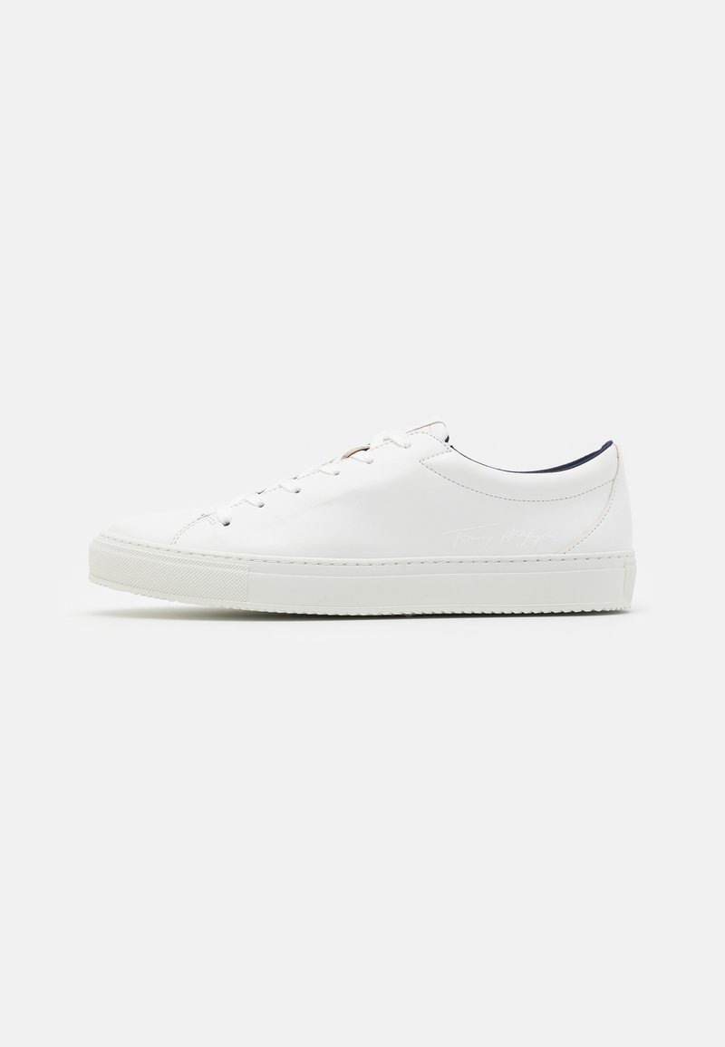 Sneaker in pelle bianca con punta tonda, suola piatta in gomma e design con lacci. Presenta cuciture minime e un interno a contrasto in colore navy.