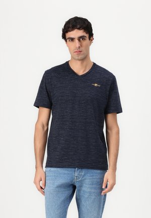 T-shirt en coton bleu marine avec un col en V et des manches courtes, présentant une finition texturée subtile et un petit logo doré sur la poitrine.