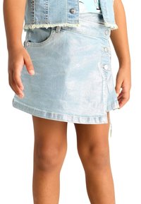 Gonna di denim azzurro chiaro con design avvolgente, caratterizzata da una finitura lucida, bottoni argentati e orlo sfrangiato. Di lunghezza corta, arriva a metà coscia.