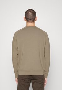 Kaki sweatshirt med rundad halsringning, ribbade ärmslut och nederkant. Mjuk tyg med slät yta, med raglanärmar för ökad komfort.