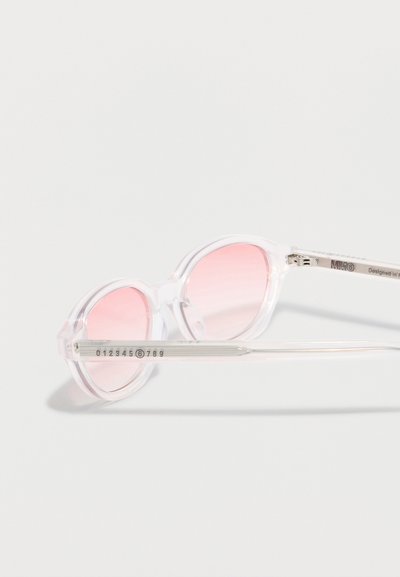 Διαφανή στρογγυλά γυαλιά ηλίου με διάφανα πλαίσια και ροζ φακούς με κλίση, που παρουσιάζουν αριθμητική λεπτομέρεια στο μπράτσο.