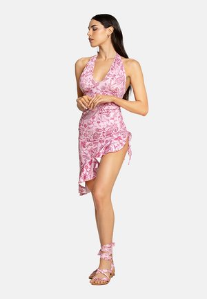 Abito halter rosa con motivo, orlo arricciato e legatura laterale, abbinato a sandali avvolgenti coordinati. Realizzato in tessuto leggero.