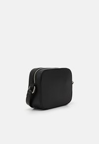 Black textured crossbody bag with a rectangular shape, zip closure, adjustable strap, and silver hardware accents.