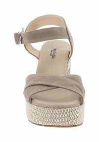 Sandalo platform beige in suede con cinturini incrociati e fibbia alla caviglia. Texture intrecciata sulla base della piattaforma; interno liscio.