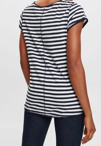T-shirt a righe in blu navy e bianco, con maniche corte e collo arrotondato. Materiale in cotone morbido con dettagli di cucitura visibili.