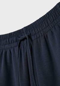 Marineblaue Sweatpants verfügen über einen dehnbaren Bund mit Kordelzug, eine weiche Textur und einen glatten Stoff mit dezenten Nähdetails.