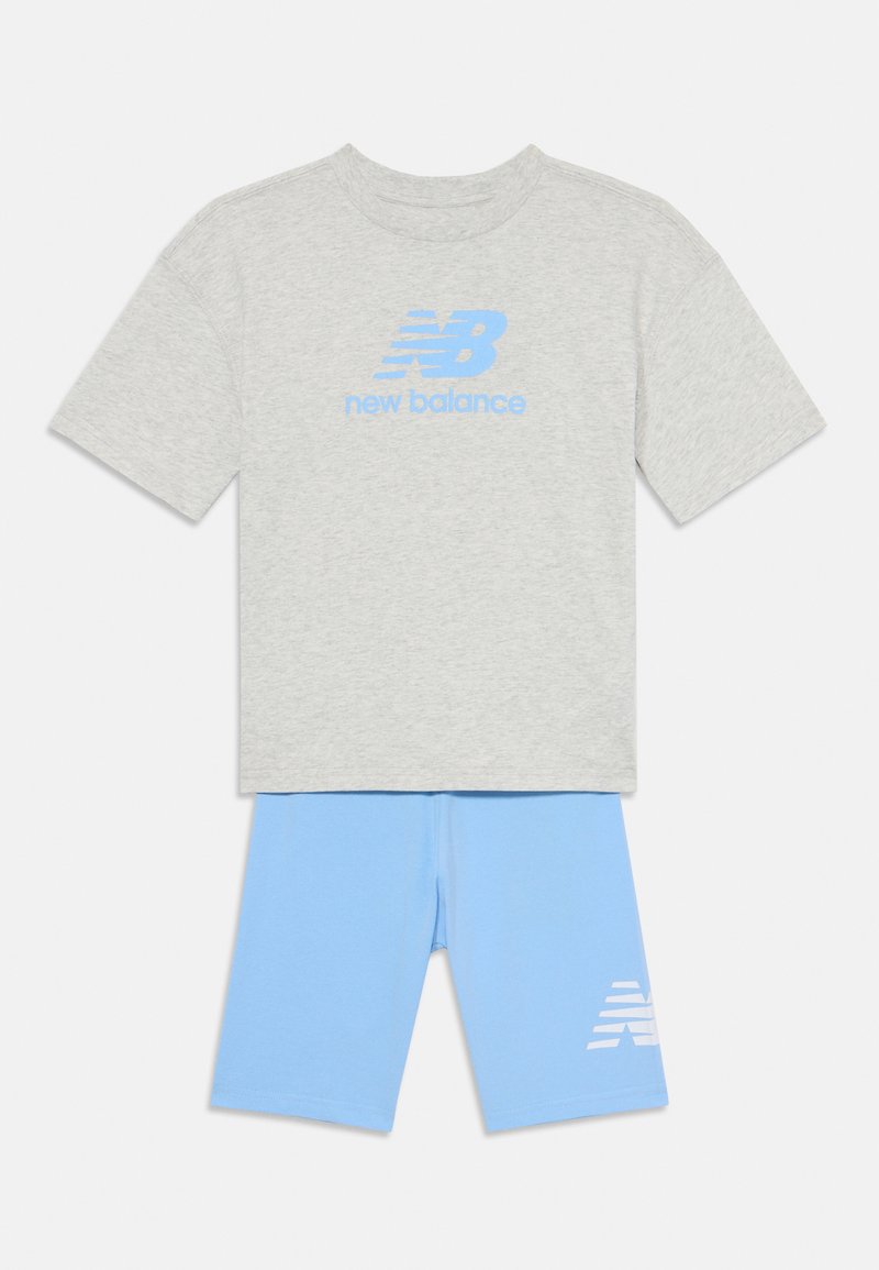 Γκρι βαμβακερό T-shirt με μπλε λογότυπο "New Balance", συνδυασμένο με ανοιχτό μπλε σορτς που έχει λευκή εκτύπωση λογότυπου στο αριστερό πόδι.
