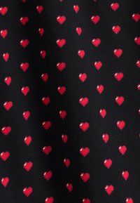 Czarna tkanina z powtarzającym się wzorem małych czerwonych serc z białymi refleksami, równomiernie rozmieszczonych na powierzchni.