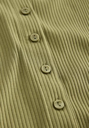 Ribbelfabric i olivgrön, med fem runda knappar med två hål i varje, som framhäver textur och designdetaljer.