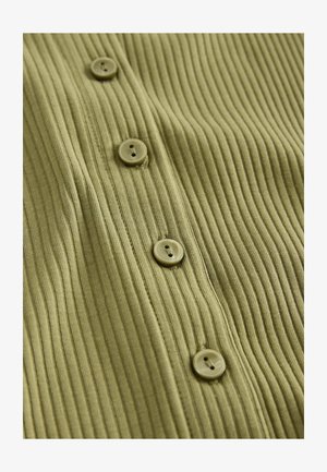 Roheline ribbed kangas viie ümmarguse nupuga, millest igal on kaks auku, rõhutades tekstuuri ja disainielemente.