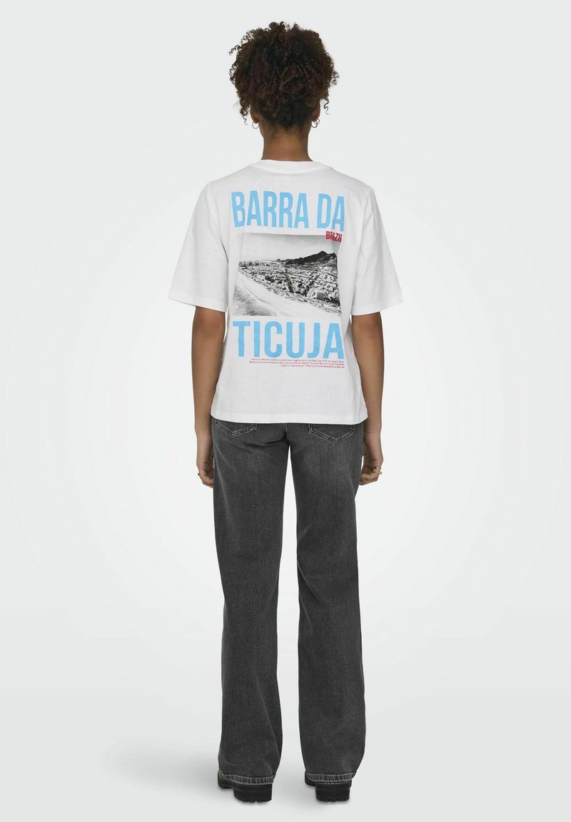 Witte t-shirt met een zwart-wit grafisch ontwerp van een landschap, met "BARRA DA TICUJA" in blauwe en rode tekst op de achterkant. Casual fit.