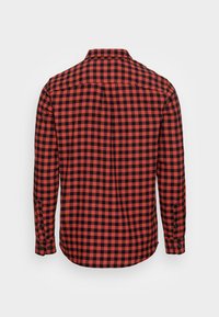 Chemise à manches longues à carreaux rouges et noirs en coton avec des poignets à bouton et un col, comportant un design de partie arrière.