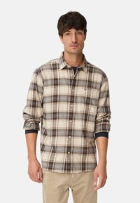 Chemise pour homme à carreaux avec boutons, dans des tons beiges, bruns et gris ; dotée d'une poche, d'un col et de manches retroussées avec des accents bleu marine.
