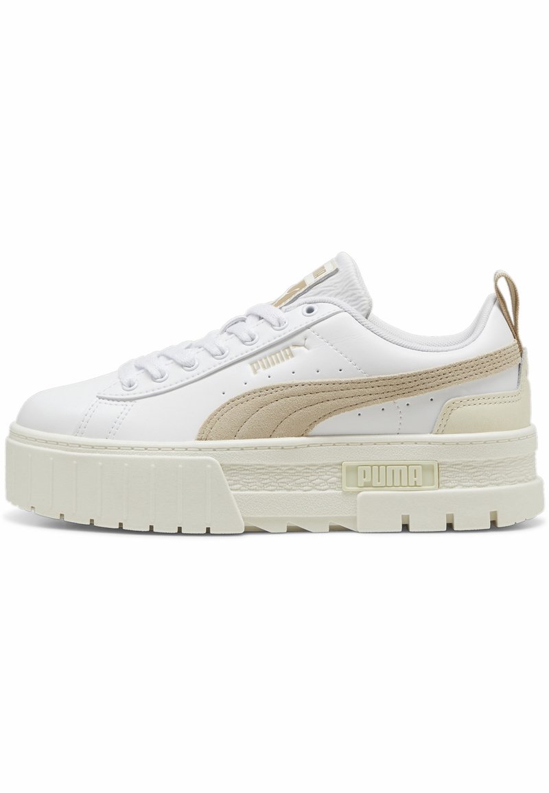 Bílé platformové tenisky s béžovým semišovým akcentem. Mají gumovou podrážku, kulatou špičku, šněrování a malé logo na boku.