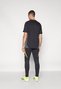 adidas Performance JAMAICA JFF TRAINING PANT - Leggings - black/semi solar gold