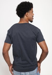 Mörkgrå, kortärmad t-shirt med rund halsringning, tillverkad av mjukt bomull. Har en enkel design utan mönster eller detaljer.