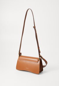 Brown leather crossbody bag with a rectangular shape, adjustable strap, gold hardware, and a smooth finish. Brand logo displayed on the front.